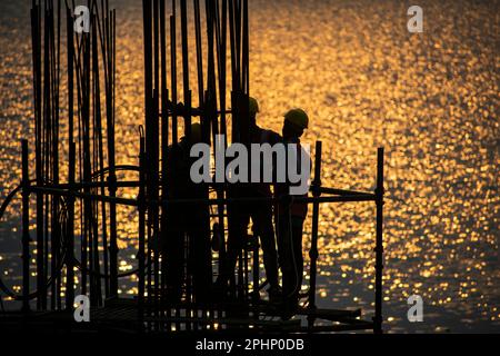 Guwahati, Inde. 27 mars 2023. Les ouvriers de la construction se sont occupés à fabriquer un poteau en béton près de la rivière Brahmaputra à Guwahati. Banque D'Images