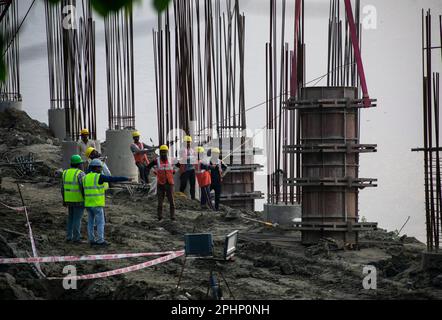 Guwahati, Inde. 27 mars 2023. Les ouvriers de la construction se sont occupés à fabriquer un poteau en béton près de la rivière Brahmaputra à Guwahati. Banque D'Images