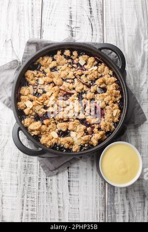 Tarte aux fruits suédois avec sauce à la vanille maison, à deux pas de la table en bois. Vue verticale du dessus Banque D'Images