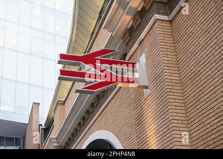 Londres, Royaume-Uni - 01 février 2019 : logo rouge du chemin de fer britannique sur un mur de briques orange. National Rail est la principale société de transport en commun qui exploite i Banque D'Images