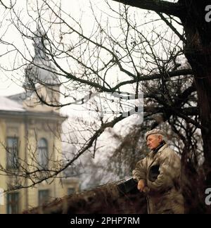 Pologne. Province de la Pologne inférieure. Vieil homme à l'extérieur surplombant le bâtiment historique. Banque D'Images