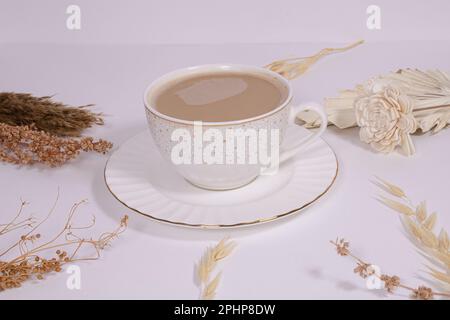 Tasse de café en porcelaine esthétique blanche avec fleurs beiges sur fond blanc classique, image ID: 2PHP8DW Banque D'Images