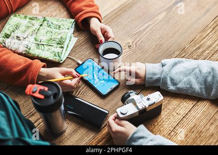 Vacances en famille. Jeune fille recherchant une destination et des itinéraires de voyage à l'aide d'une carte de navigation sur un téléphone portable. Chargement du smartphone avec la batterie portable. Banque D'Images