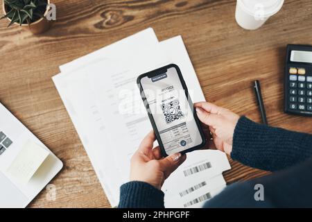 Femme payant la facture scannant le code QR à partir du document à l'aide d'un système de paiement sécurisé rapide et d'un scanner QR pour smartphone. Femme d'affaires qui paie les factures en utilisant expr Banque D'Images