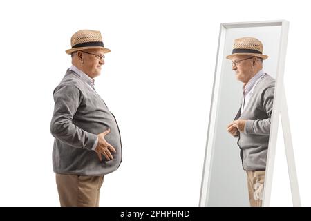 Homme âgé avec un grand ventre debout devant un miroir isolé sur fond blanc Banque D'Images