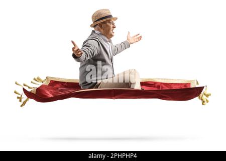 Photo de profil d'un homme âgé volant avec un tapis de velours rouge et un bonheur gesturant isolé sur fond blanc Banque D'Images