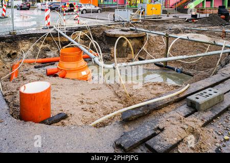 Remplacement des conduites d'eau souterraine, d'eau de pluie et d'égout à l'intersection des rues de la ville à l'aide d'un système d'assèchement Banque D'Images