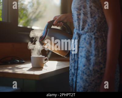La femme boit du café, routine du matin. Petite maison. Première propriété. Design intérieur de petit appartement. Minimalisme. Entrée en marche. Vivre seul. Charmant Banque D'Images