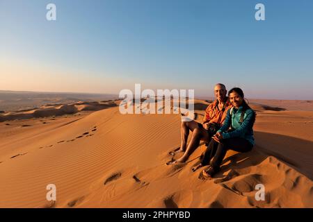 Couple appréciant le désert dans les sables de Wahiba, Oman Banque D'Images