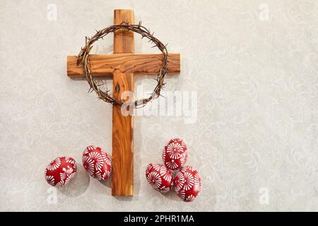 Croix chrétienne et œufs de Pâques colorés sur fond vintage Banque D'Images