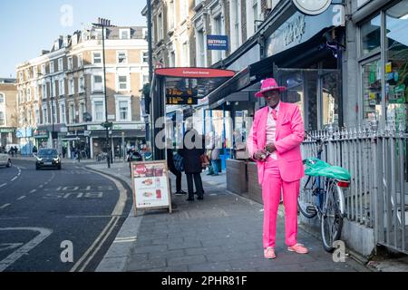 Londres- janvier 2023: Un homme portant un costume rose sur Harrow Road W9 West London Banque D'Images