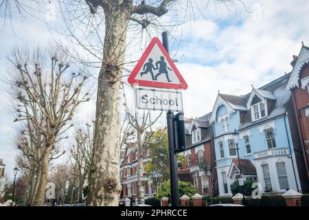 Londres - janvier 2023 : signe d'avertissement triangulaire du passage à niveau de l'école dans la zone résidentielle de W10 ouest de Londres - North Kensington Banque D'Images