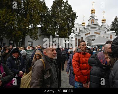 Les gens assistent à un service d'église près de l'Exaltation de l'église de la Croix de la Lavra de Kiev-Pechersk à Kiev dans le cadre de l'invasion russe de l'Ukraine. Kiev-Pechersk Lavra, également connu sous le nom de monastère des grottes de Kiev, est le plus ancien monastère du territoire ukrainien. Actuellement, le ministère ukrainien de la Culture a publié une déclaration sur 10 mars 2023, disant que la Réserve nationale 'Kyiv-Pechersk Lavra' a envoyé un avertissement au monastère Kyiv-Pechersk Lavra de l'Église orthodoxe ukrainienne (Patriarcat de Moscou) au sujet de sa résiliation. L'annonce fait suite à un décret présidentiel d'interdiction de décembre 2022 Banque D'Images