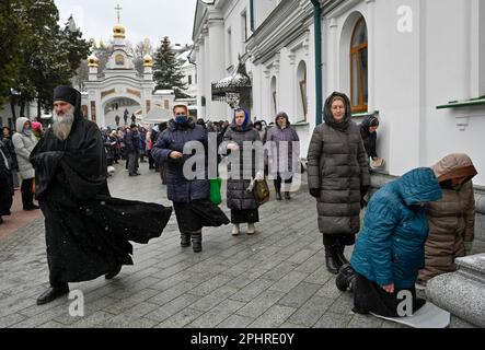 Les gens assistent à un service d'église près de l'Exaltation de l'église de la Croix de la Lavra de Kiev-Pechersk à Kiev dans le cadre de l'invasion russe de l'Ukraine. Kiev-Pechersk Lavra, également connu sous le nom de monastère des grottes de Kiev, est le plus ancien monastère du territoire ukrainien. Actuellement, le ministère ukrainien de la Culture a publié une déclaration sur 10 mars 2023, disant que la Réserve nationale 'Kyiv-Pechersk Lavra' a envoyé un avertissement au monastère Kyiv-Pechersk Lavra de l'Église orthodoxe ukrainienne (Patriarcat de Moscou) au sujet de sa résiliation. L'annonce fait suite à un décret présidentiel d'interdiction de décembre 2022 Banque D'Images