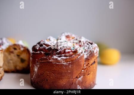 Kraffin de Pâques sur fond clair avec des œufs colorés et lumineux. Gâteau aux fruits confits, raisins secs, chocolat, noix, garniture au sucre en poudre, edibl Banque D'Images