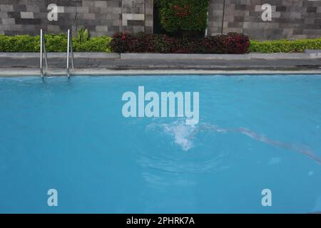 La surface de l'eau de la piscine sur fond et papier peint à texture soleil Banque D'Images