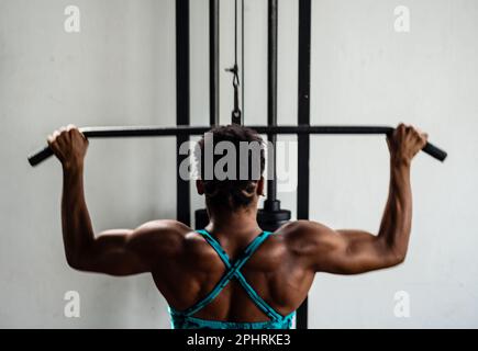 Portrait d'une femme musculaire faisant des exercices de traction pour les muscles du dos. Concept de santé. Banque D'Images