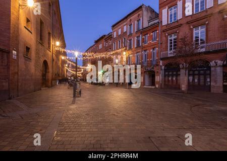 Les vieilles rues pavées de Toulouse au crépuscule illuminées par des lumières Banque D'Images