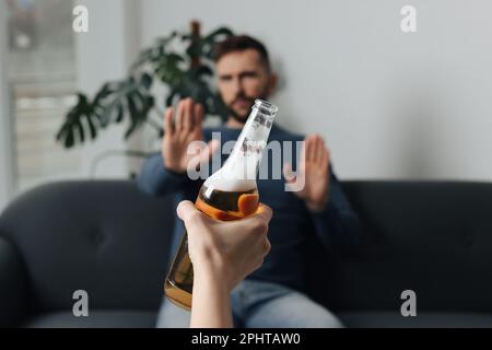 Homme refusant de boire de la bière à l'intérieur, en gros plan. Traitement de la dépendance à l'alcool Banque D'Images