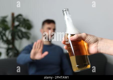 Homme refusant de boire de la bière à l'intérieur, en gros plan. Traitement de la dépendance à l'alcool Banque D'Images