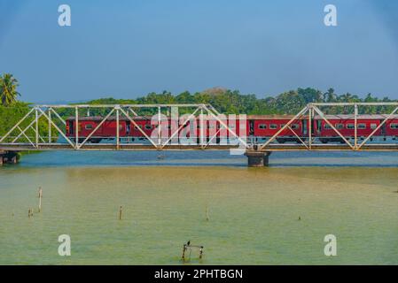 Train traversant la lagune de Koggala sur un pont, Sri Lanka. Banque D'Images