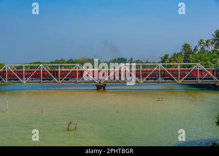 Train traversant la lagune de Koggala sur un pont, Sri Lanka. Banque D'Images