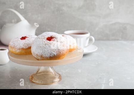 Présentoir à pâtisseries avec délicieux beignets en gelée sur table grise. Espace pour le texte Banque D'Images