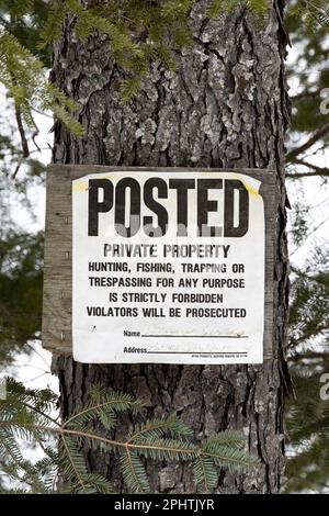 Une ancienne affiche décolorée - propriété privée - panneau sur un panneau cloué à un arbre dans les montagnes Adirondack, NY USA Banque D'Images