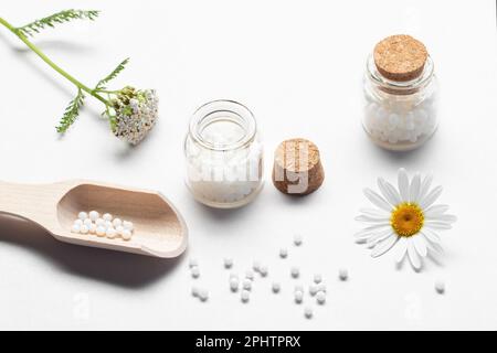 Composition des médicaments homéopathiques et des plantes médicinales sur une table blanche. Banque D'Images