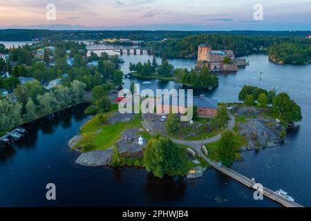 Vue sur le château d'Olavinlinna et le musée Riihisaari à Savonlinna, en Finlande, au coucher du soleil. Banque D'Images