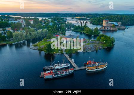 Vue sur le château d'Olavinlinna et le musée Riihisaari à Savonlinna, en Finlande, au coucher du soleil. Banque D'Images