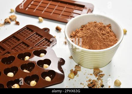 Poudre de cacao, noix et chapelure de biscuit, moules en silicone pour la fabrication de chocolat, biscuit sucré fait maison Banque D'Images