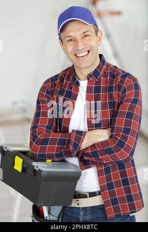 portrait d'un ouvrier mûr tenant une boîte à outils Banque D'Images