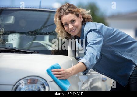 jeune femme essuyant sa voiture à sec Banque D'Images
