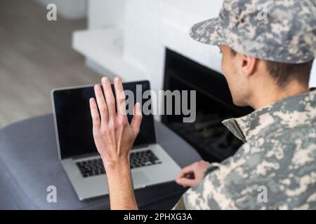 Surveillance et contrôle du concept d'information opposé, Soldier en uniforme de camouflage travaillant sur ordinateur portable pour opération d'information Banque D'Images