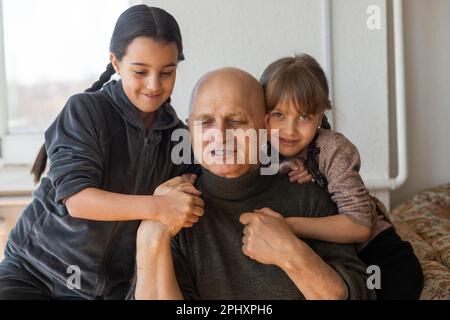Grand-père ukrainien et deux petites-filles embrassant Banque D'Images