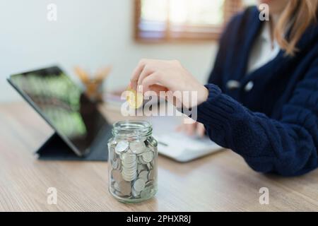 Le plan d'épargne crypto-monnaie, la jeune femme asiatique épargnant des pièces numériques dans une banque à la mode Banque D'Images