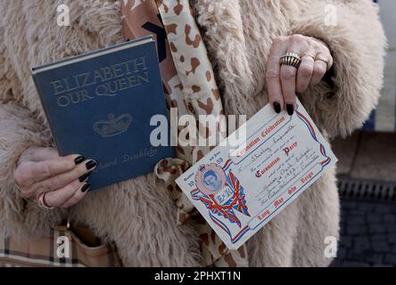 Shirley Heim, avec son billet original pour le couronnement de la rue pour le couronnement de la reine Elizabeth II en 1953 et un livre qu'elle a été donnée en tant qu'enfant, avant la visite du roi Charles III et de la reine Consort au marché de Wittenbergplatz, à Berlin, Dans le cadre de leur visite d'État en Allemagne. Date de la photo: Jeudi 30 mars 2023. Banque D'Images