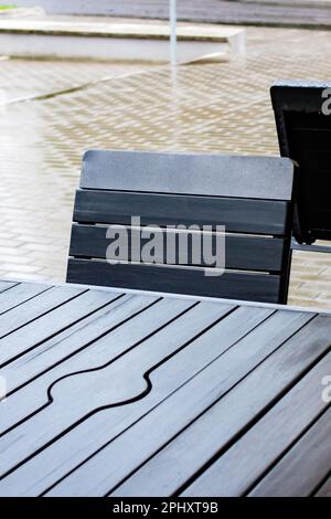 Table et chaises de rue mouillées sous la pluie Banque D'Images