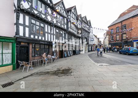 Les anciens bâtiments Tudor abritant la taverne Ye Olde Bull King et la boutique Oxfam à Kings Street, Ludlow, Shropshire, Angleterre Banque D'Images