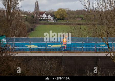 Denham, Royaume-Uni. 21st mars 2023. Un ouvrier de la construction marche le long du viaduc de la vallée de Colne pour la liaison ferroviaire à grande vitesse HS2. Le viaduc a besoin de 292 piles et transportera HS2 lacs et cours d'eau dans le parc régional de Colne Valley. Le secrétaire aux Transports, Mark Harper, a annoncé que la deuxième étape de HS2 de Birmingham à Crewe sera retardée de deux ans au moins et que les trains ne seront pas dirigés vers le centre de Londres avant 2040. Crédit : Mark Kerrison/Alamy Live News Banque D'Images