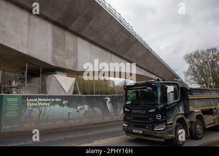 Denham, Royaume-Uni. 21st mars 2023. Un camion passe devant un chantier de construction du viaduc de la vallée de Colne pour la liaison ferroviaire à grande vitesse HS2. Le viaduc a besoin de 292 piles et transportera HS2 lacs et cours d'eau dans le parc régional de Colne Valley. Le secrétaire aux Transports, Mark Harper, a annoncé que la deuxième étape de HS2 de Birmingham à Crewe sera retardée de deux ans au moins et que les trains ne seront pas dirigés vers le centre de Londres avant 2040. Crédit : Mark Kerrison/Alamy Live News Banque D'Images