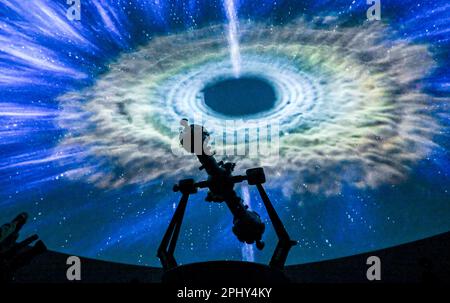 PRODUCTION - 27 mars 2023, Saxe-Anhalt, Halle (Saale): La projection d'une galaxie est visible derrière le projecteur dans la salle étoilée du planétarium. Après environ quatre ans de construction, le Planétarium de Halle est ouvert dans les murs du gasomètre historique avec un programme festif. La pièce maîtresse est la salle étoilée d'un diamètre de douze mètres, d'une hauteur de huit mètres et d'un espace pour 110 personnes. L'équipement technique permet une vue panoramique impressionnante à 360 degrés du monde des étoiles. L'argent pour les coûts de construction de 21 millions d'euros provient exclusivement de l'inondation re Banque D'Images