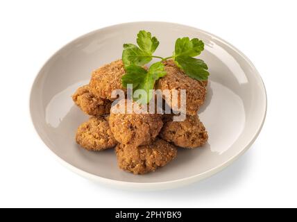 Boulettes de viande panées frites dans un plat blanc avec des feuilles de persil, isolées sur du blanc avec un passe-cheveux Banque D'Images