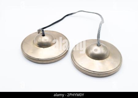 Tingsha bouddhiste tibétaine (cymbales tibétains) avec bracelet en cuir isolé sur blanc Banque D'Images