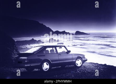 Image numérisée d'une voiture Turbo Classic Saab sur une plage déserte à Devon, au Royaume-Uni, filmée vers 1994 Banque D'Images