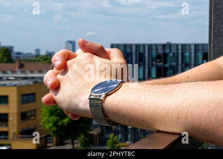 Jeune homme se détendant sur un balcon portant une montre de mode - Londres, Royaume-Uni, 1st juin Banque D'Images