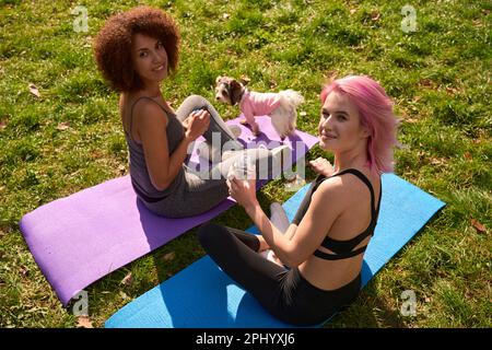 Deux sportswomen se reposant sur l'herbe après l'entraînement en plein air Banque D'Images