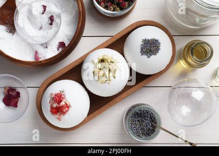 Composition de pose plate avec bombes de bain et ingrédients sur table en bois blanc Banque D'Images