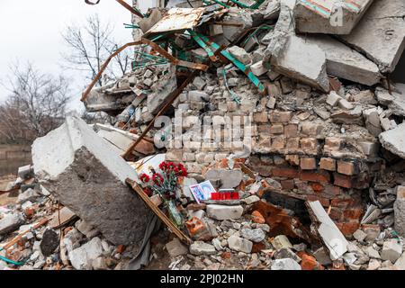 19 mars 2023, Izium, Oblast de Kharkiv, Ukraine: Photos des morts, bougies commémoratives et fleurs sur la scène de la mort des résidents de la maison détruite peut être vu à Izyum. Izyum dans la région de Kharkiv en Ukraine, six mois après le retrait de l'armée russe. Bien que la ville ne soit plus en feu, il existe encore un risque élevé d'explosions dues à la présence de mines, de câbles trip et de munitions non explosées. Izyum a été libéré le 10 septembre 2022 lors d'une contre-offensive des forces armées ukrainiennes, mais la ville a été gravement endommagée par les bombardements et l'occupation russes, avec 80% de t Banque D'Images